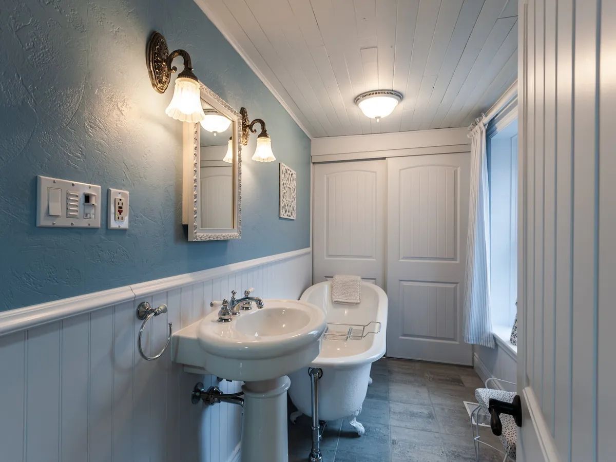 A bathroom with blue walls , a sink , and a bathtub.