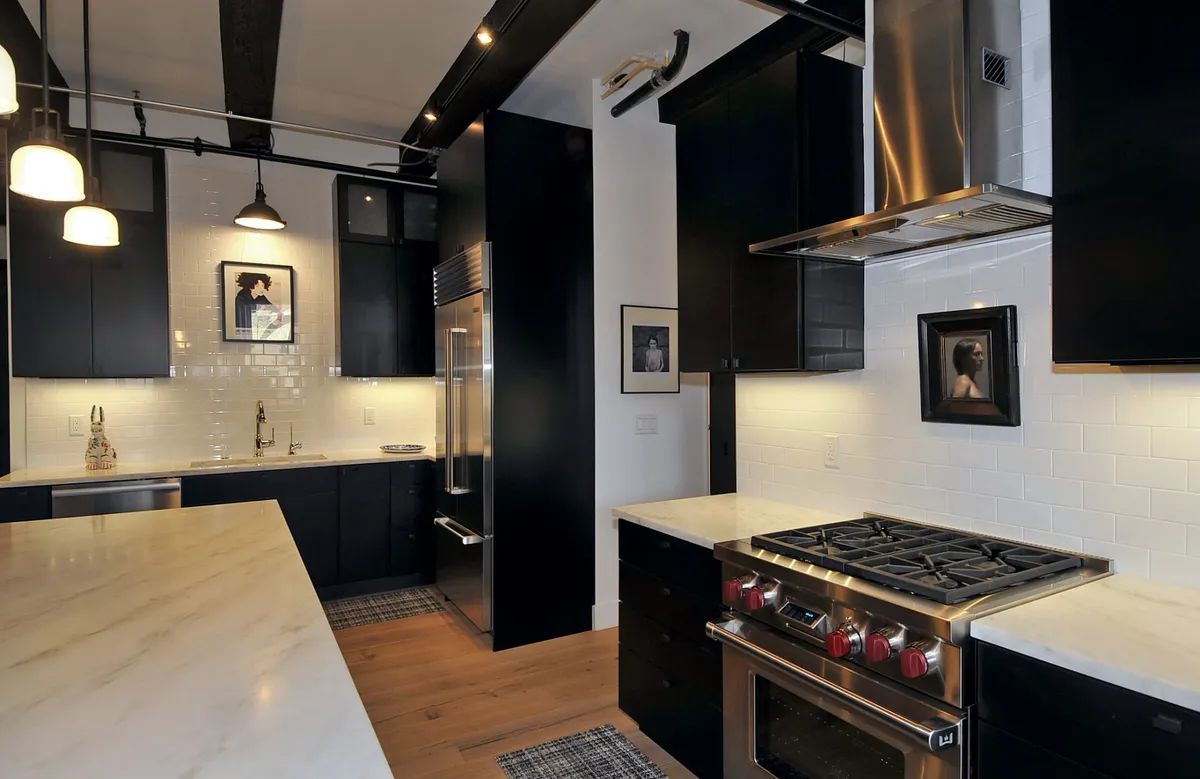 A kitchen with black cabinets and stainless steel appliances