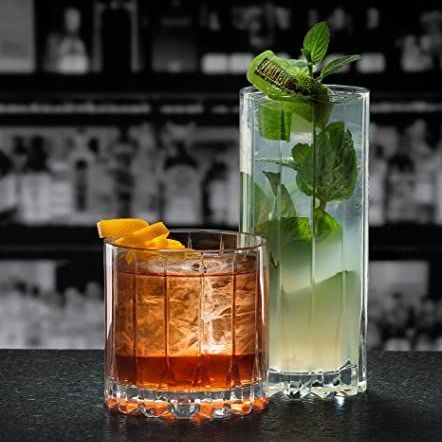 Two glasses of drinks are sitting on a bar counter.