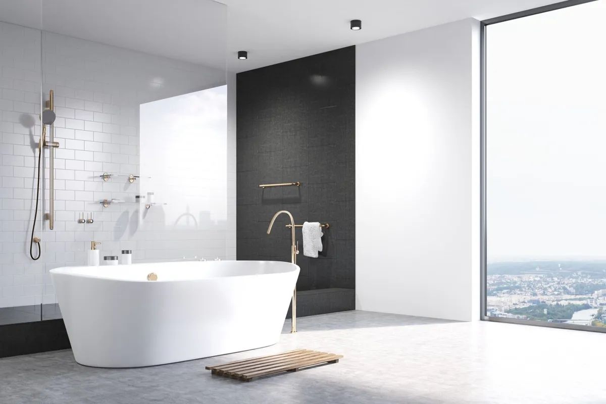 A bathroom with a bathtub , shower , and large window.