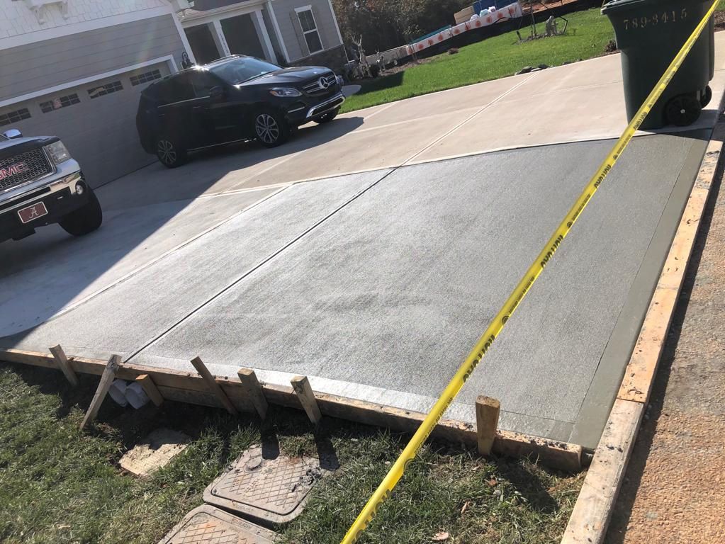 A concrete driveway is being built in front of a house.