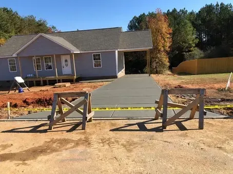 A concrete driveway is being built in front of a house.