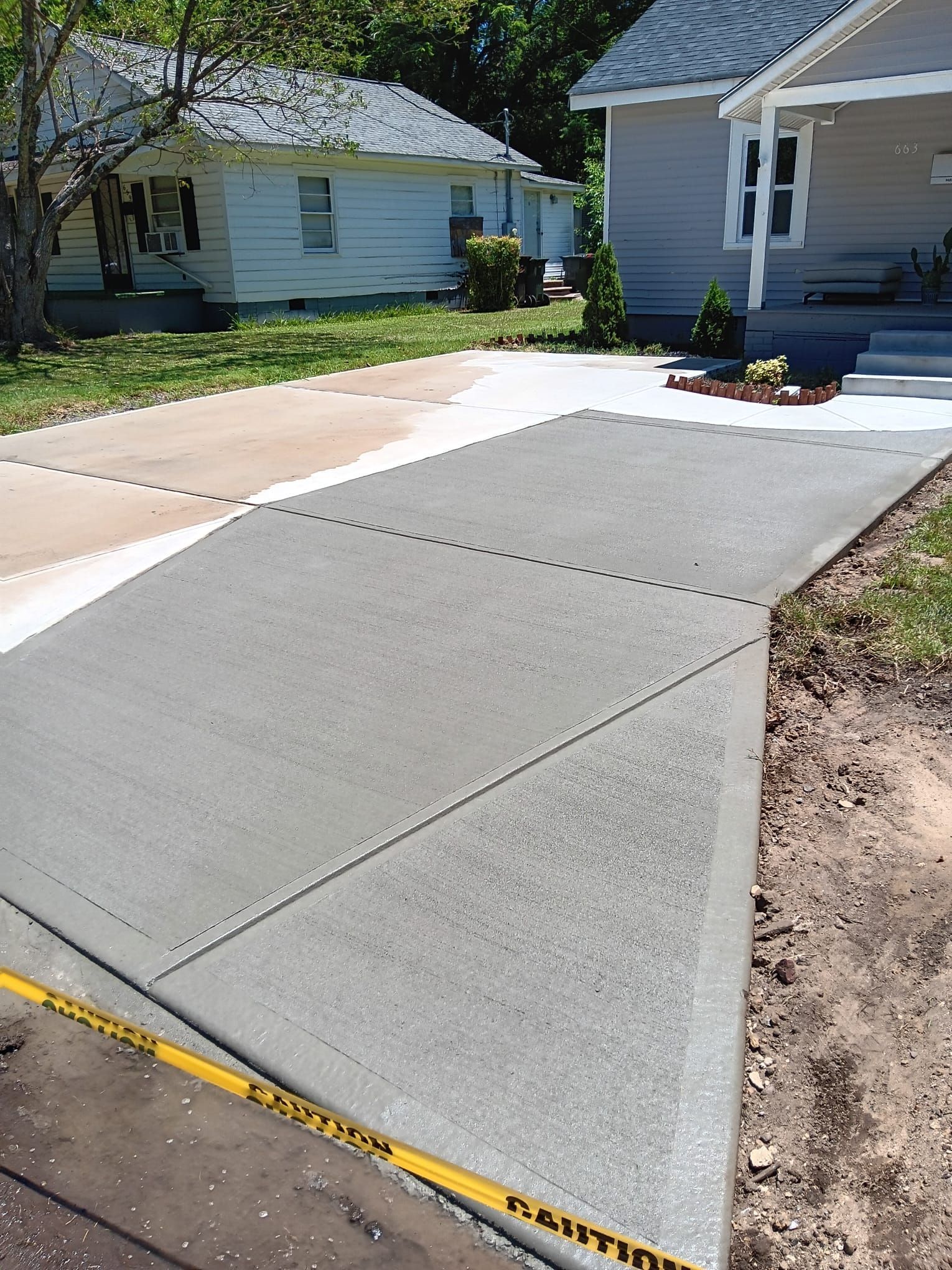 A concrete driveway is being built in front of a house.