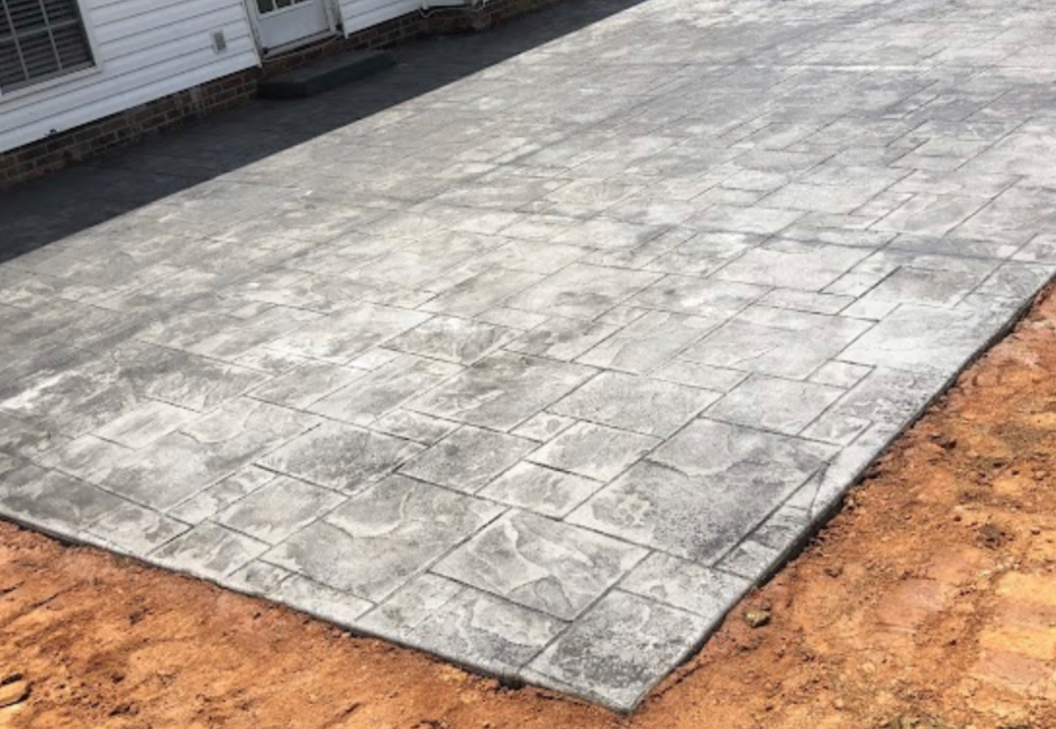 A concrete driveway is being built in front of a house.