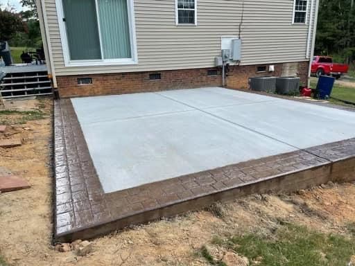 A concrete patio is being built in front of a house.