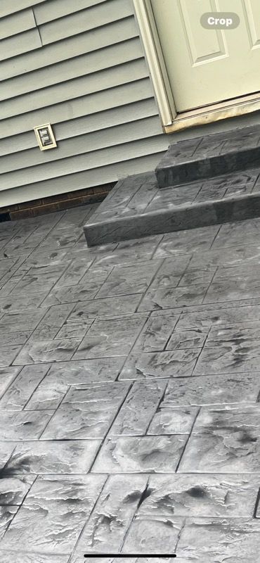 A concrete walkway with steps leading up to a door.