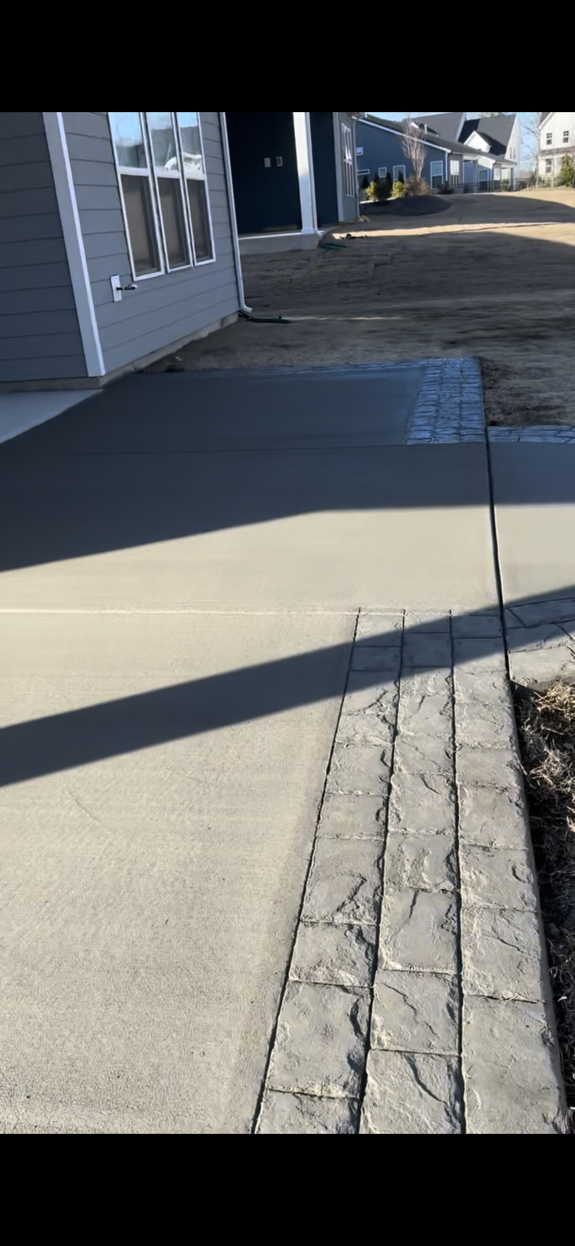 A person is walking down a sidewalk next to a building.