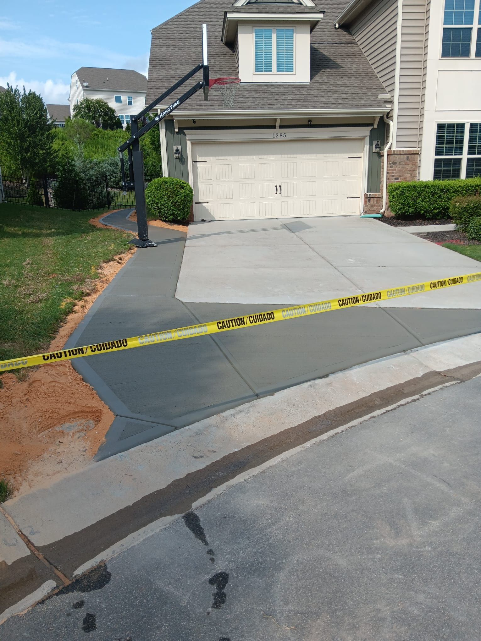 A basketball hoop is in the driveway of a house