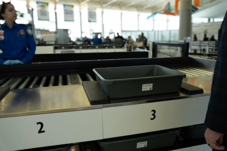 A man standing in front of a conveyor belt with the number 2 and 3 on it