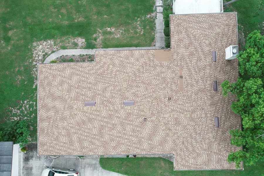 An aerial view of a house with a car parked in front of it.