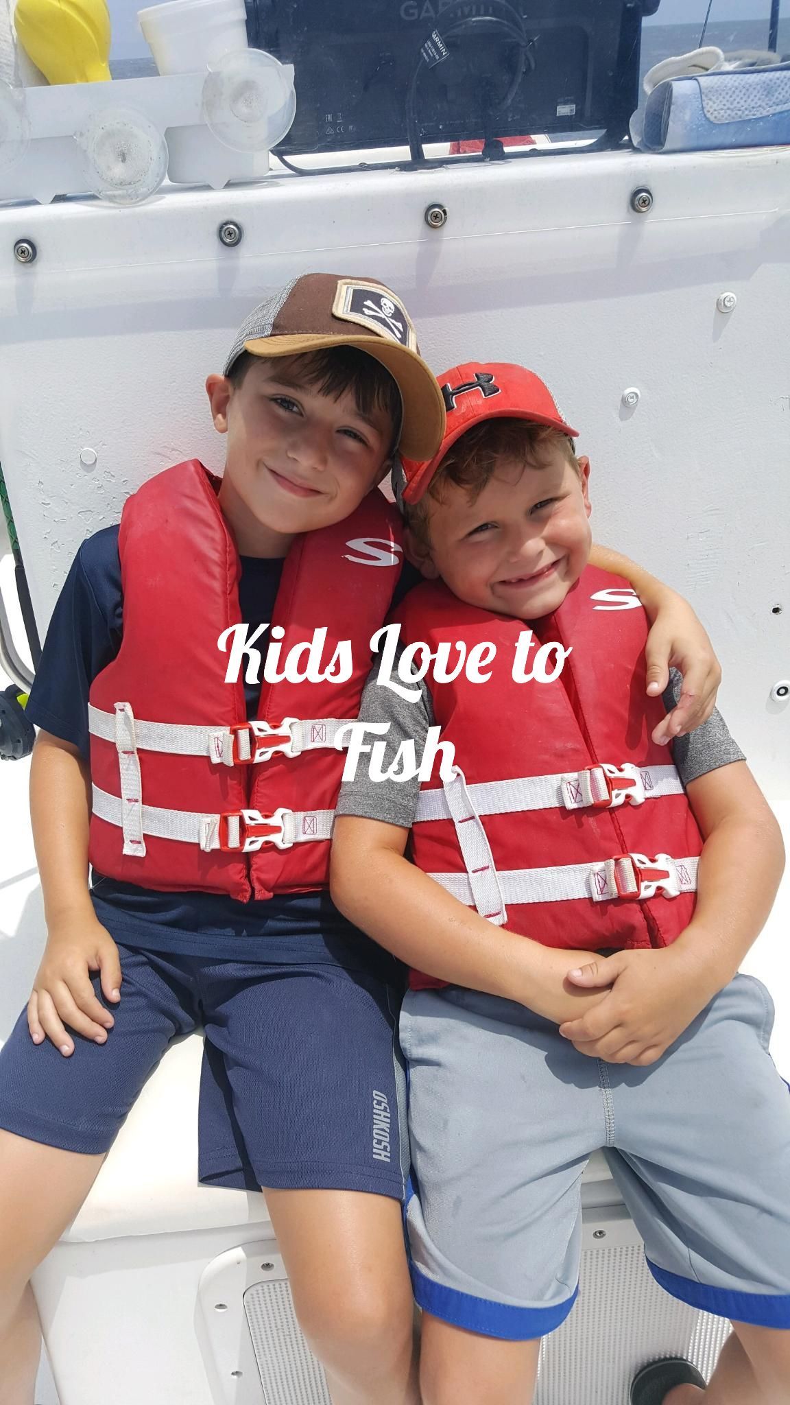 Two children wearing life vests smile on a boat. Text says, 