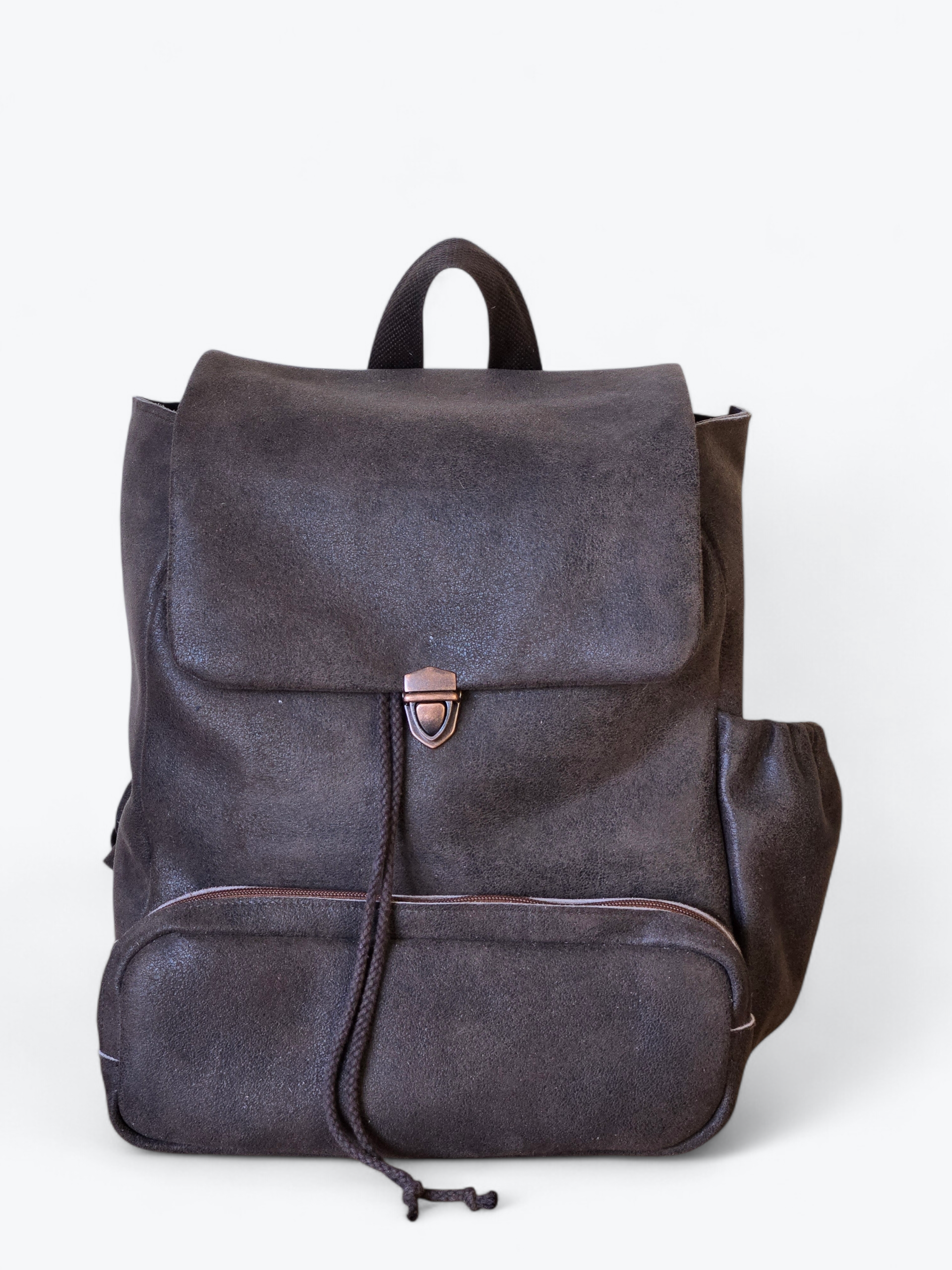 Donkere, glinsterende rugzak met klepsluiting en voorvak.