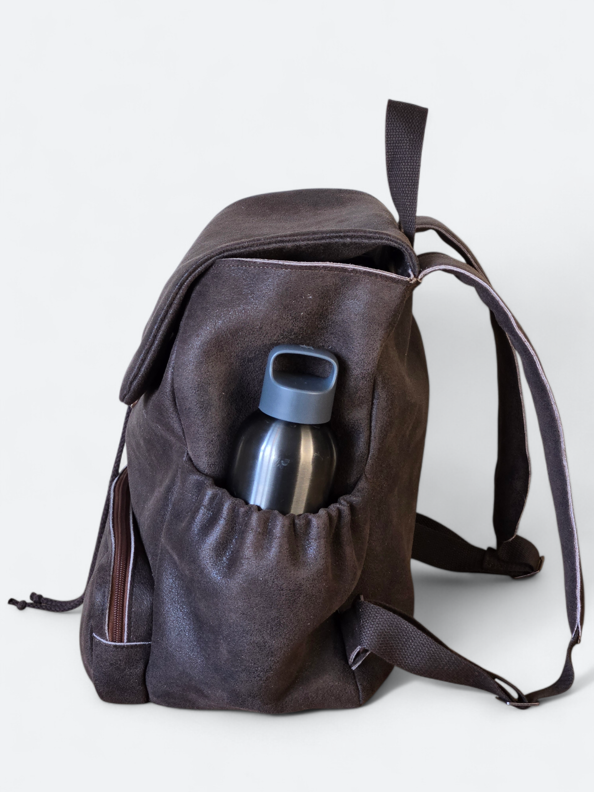 Bruine rugzak met waterfles in zijvak, tegen een witte achtergrond.