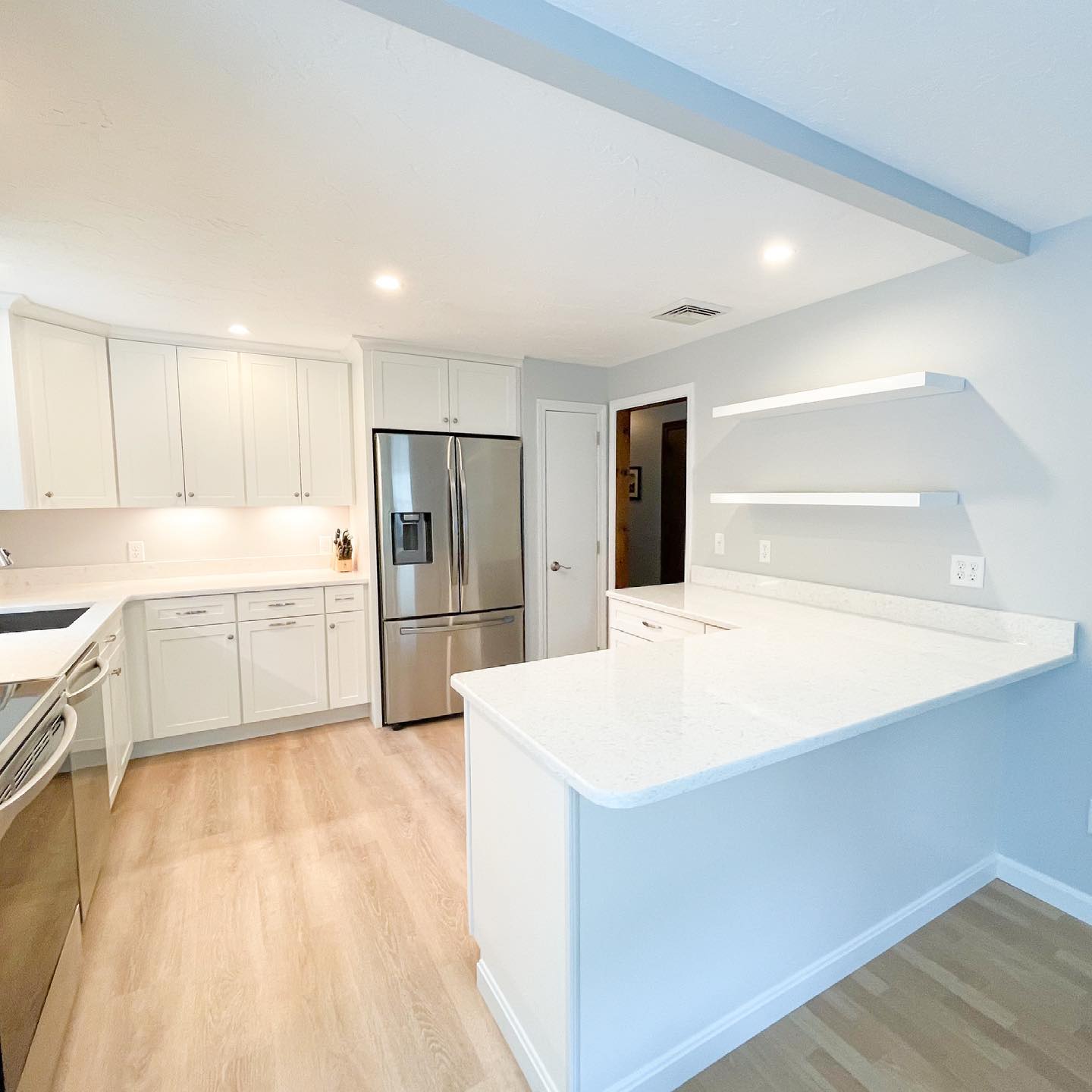 A kitchen with stainless steel appliances and white cabinets