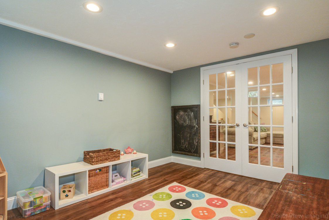 A play room with a colorful rug and a chalkboard on the wall.