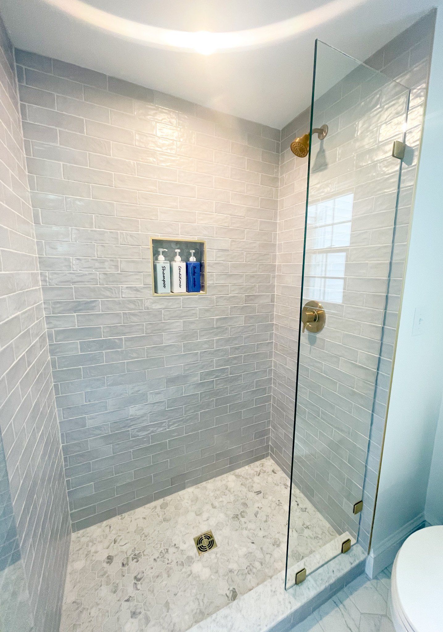 A bathroom with a walk in shower and a toilet.