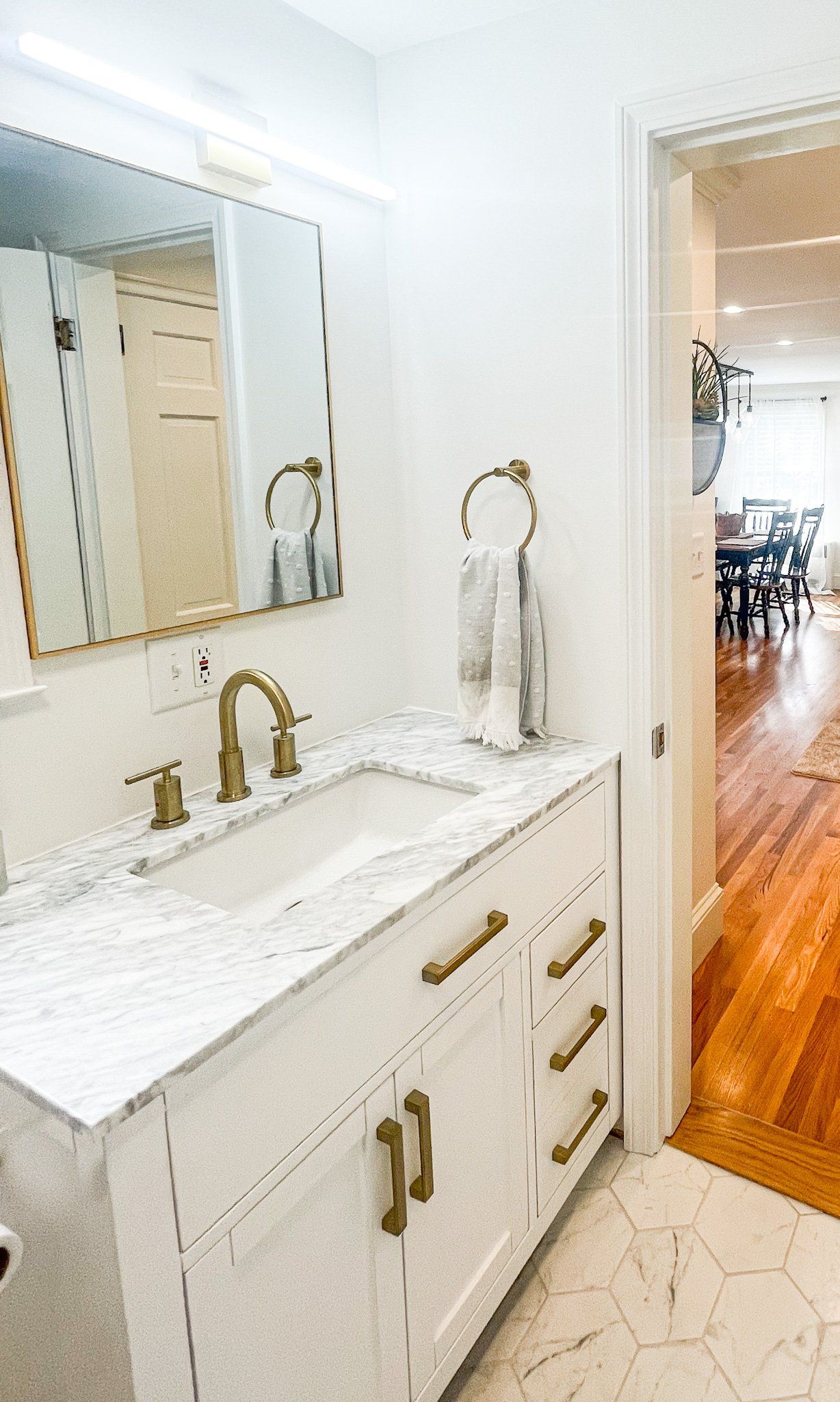 A bathroom with a sink , mirror and cabinets.