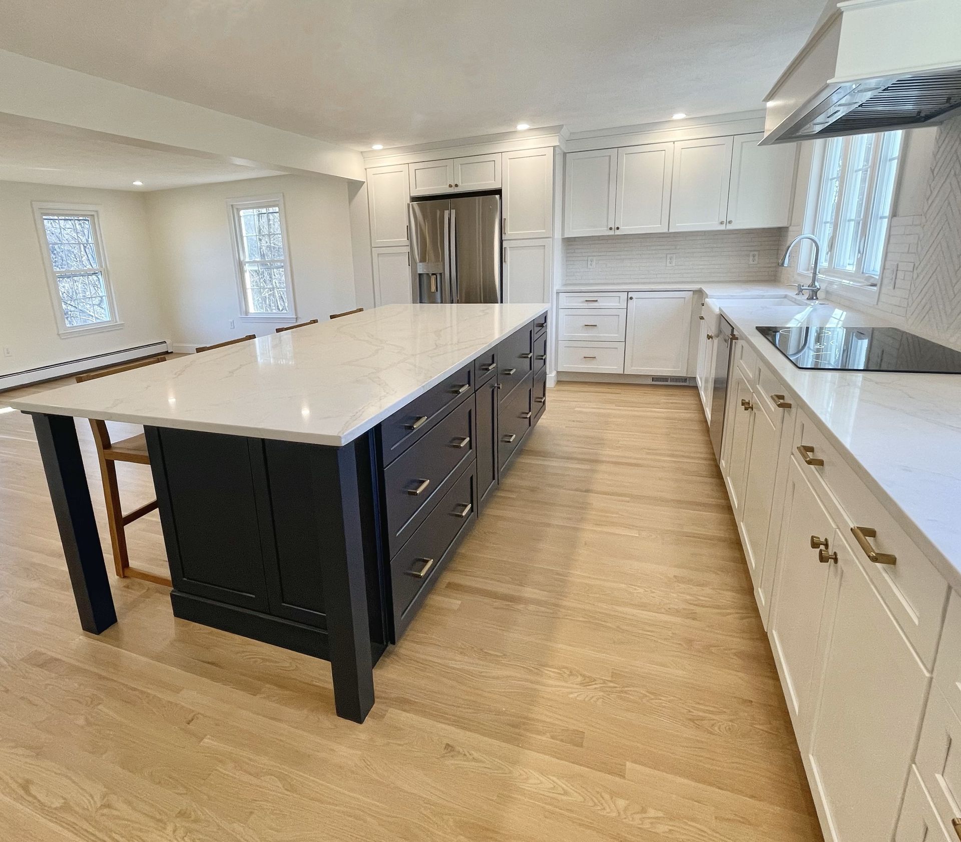 A kitchen with white cabinets and a large island in the middle