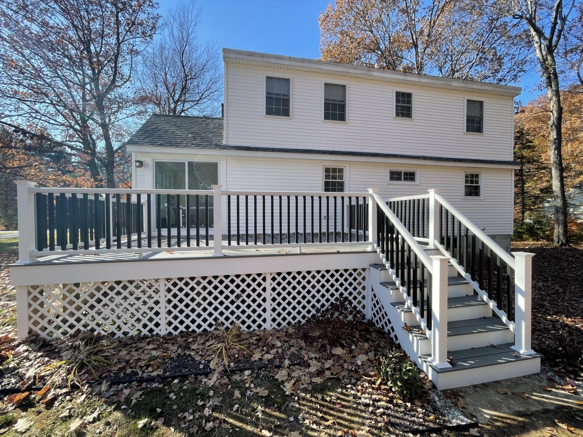 A white house with a large deck and stairs