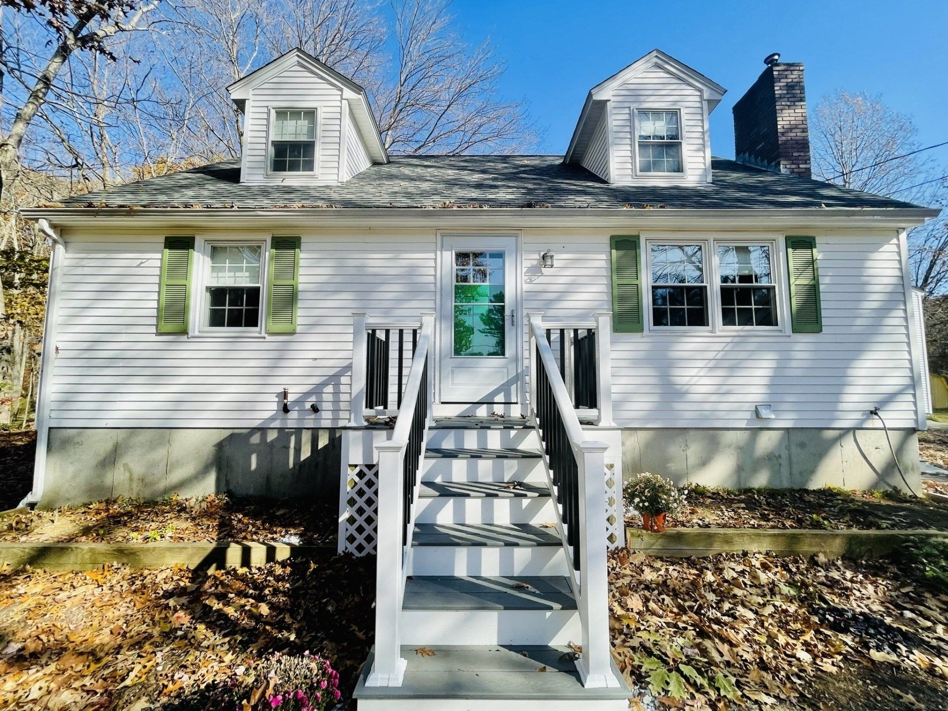 A white house with stairs leading up to the front door.