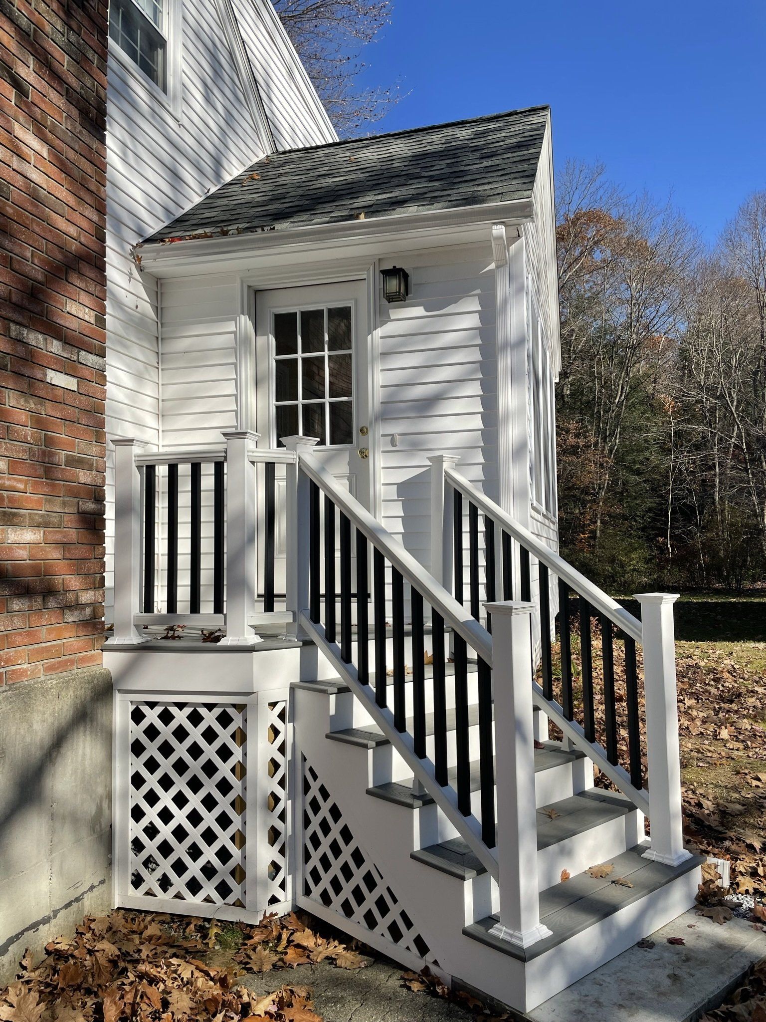 A white house with a porch and stairs leading up to it.