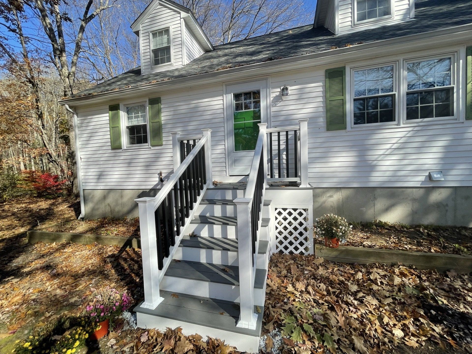 A white house with stairs leading up to the front door.