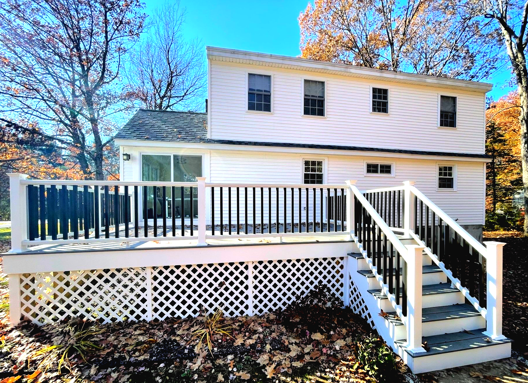 A white house with a large deck and stairs