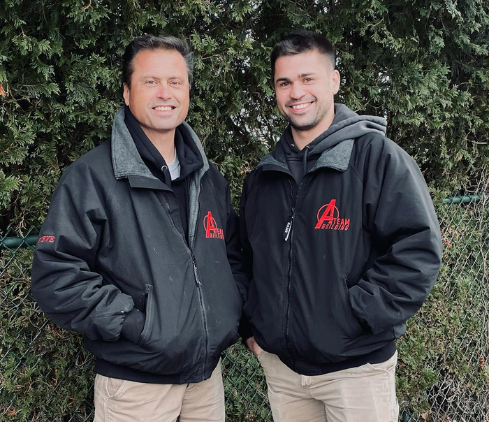 Two men wearing black jackets with the letter a on them