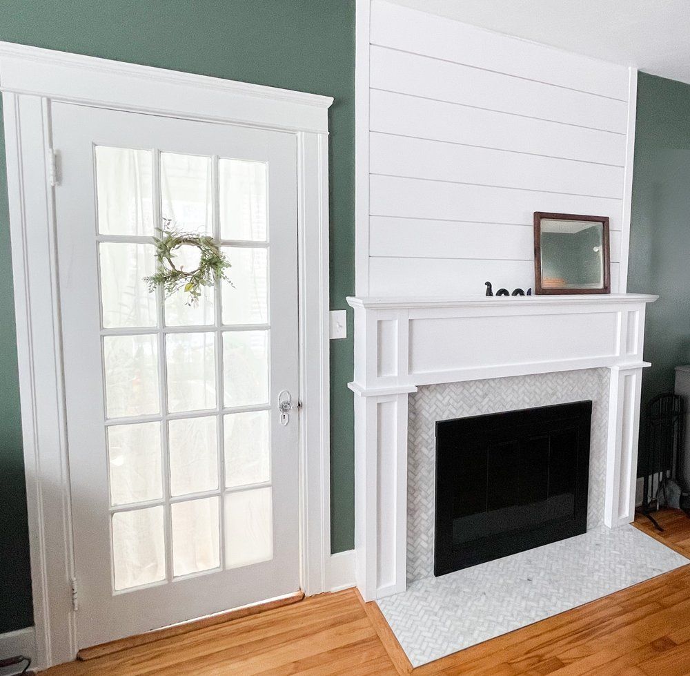 A living room with a fireplace and a french door.
