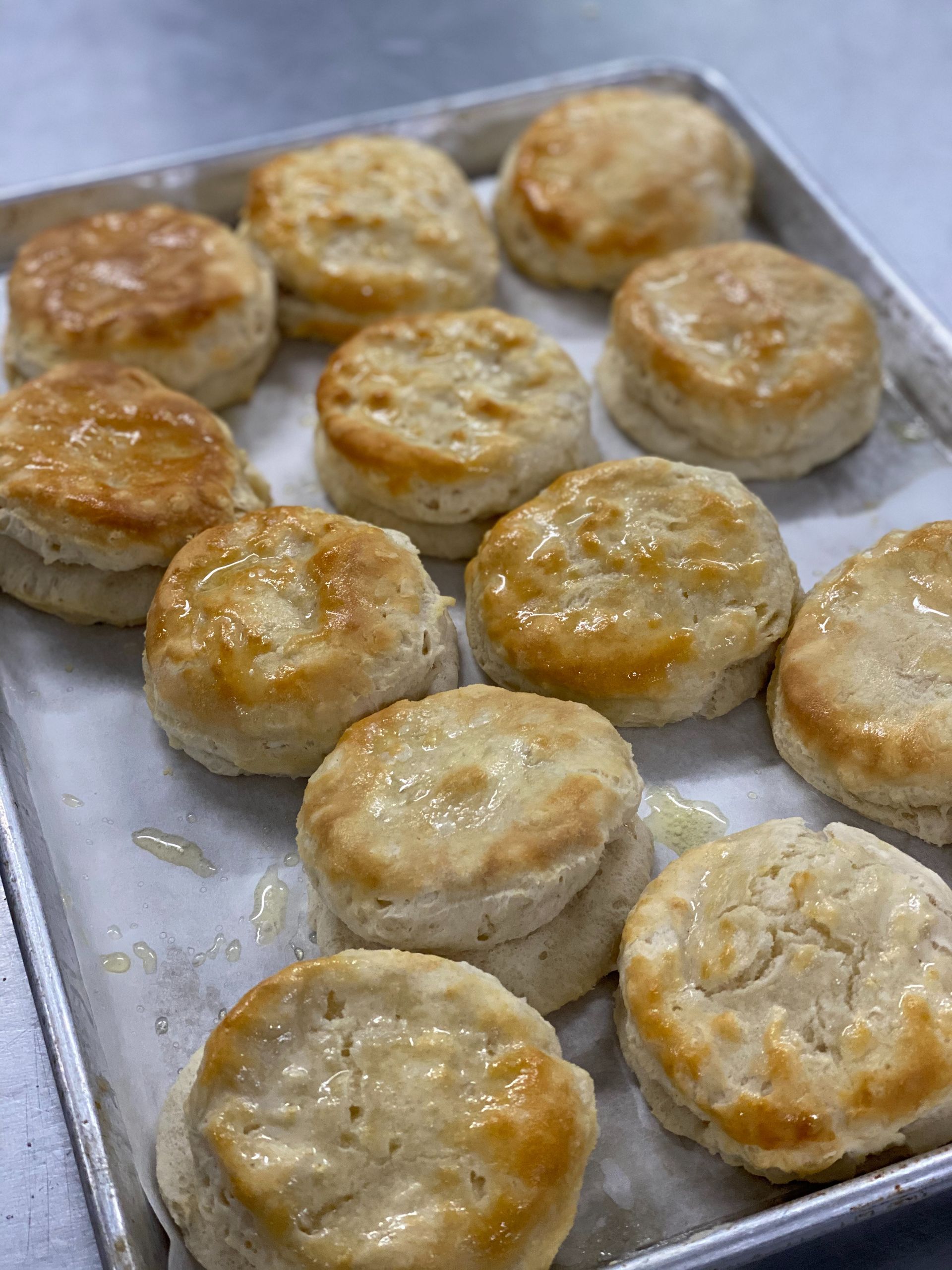 Glazed round biscuits baking on a metal tray