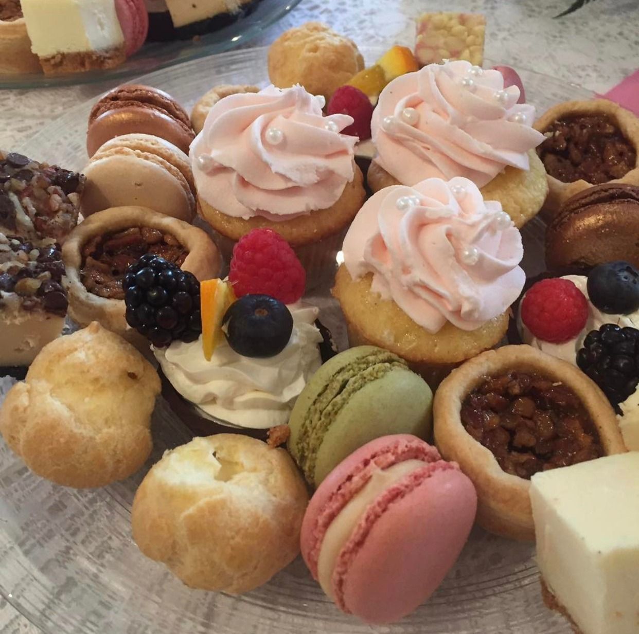Assorted colorful bite-sized pastries and macarons on a dessert platter