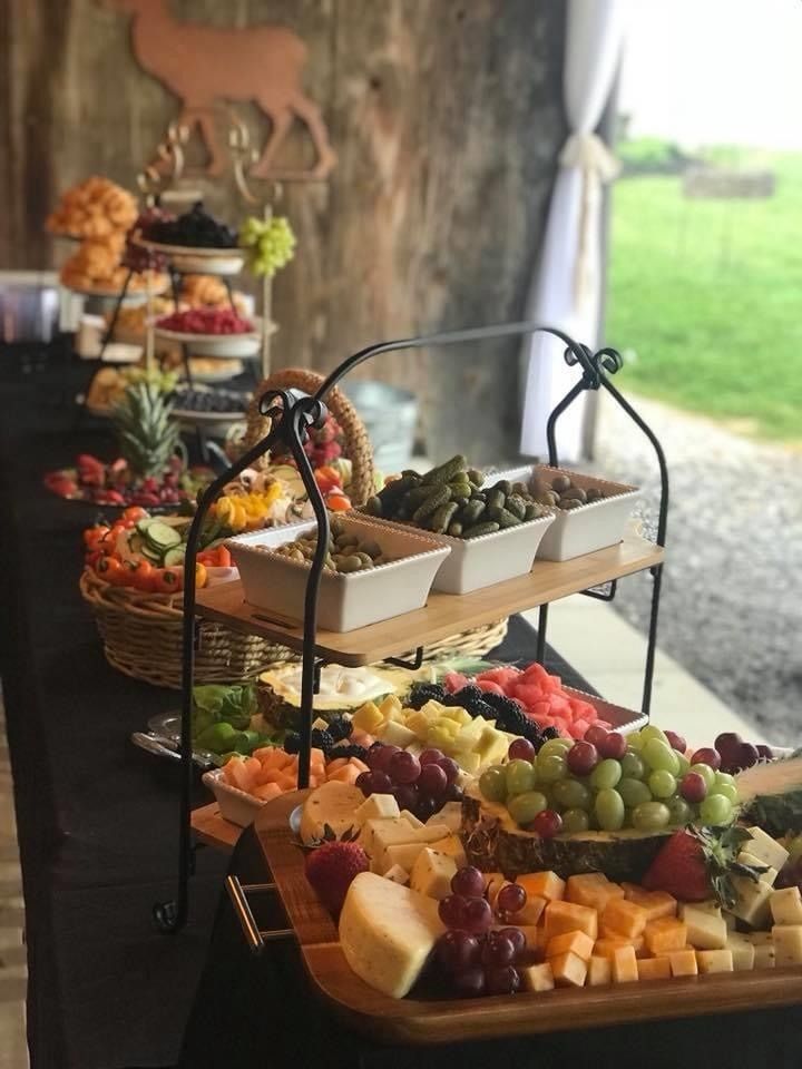 Tiered fruit platters on tables in a rustic indoor-outdoor buffet setting.
