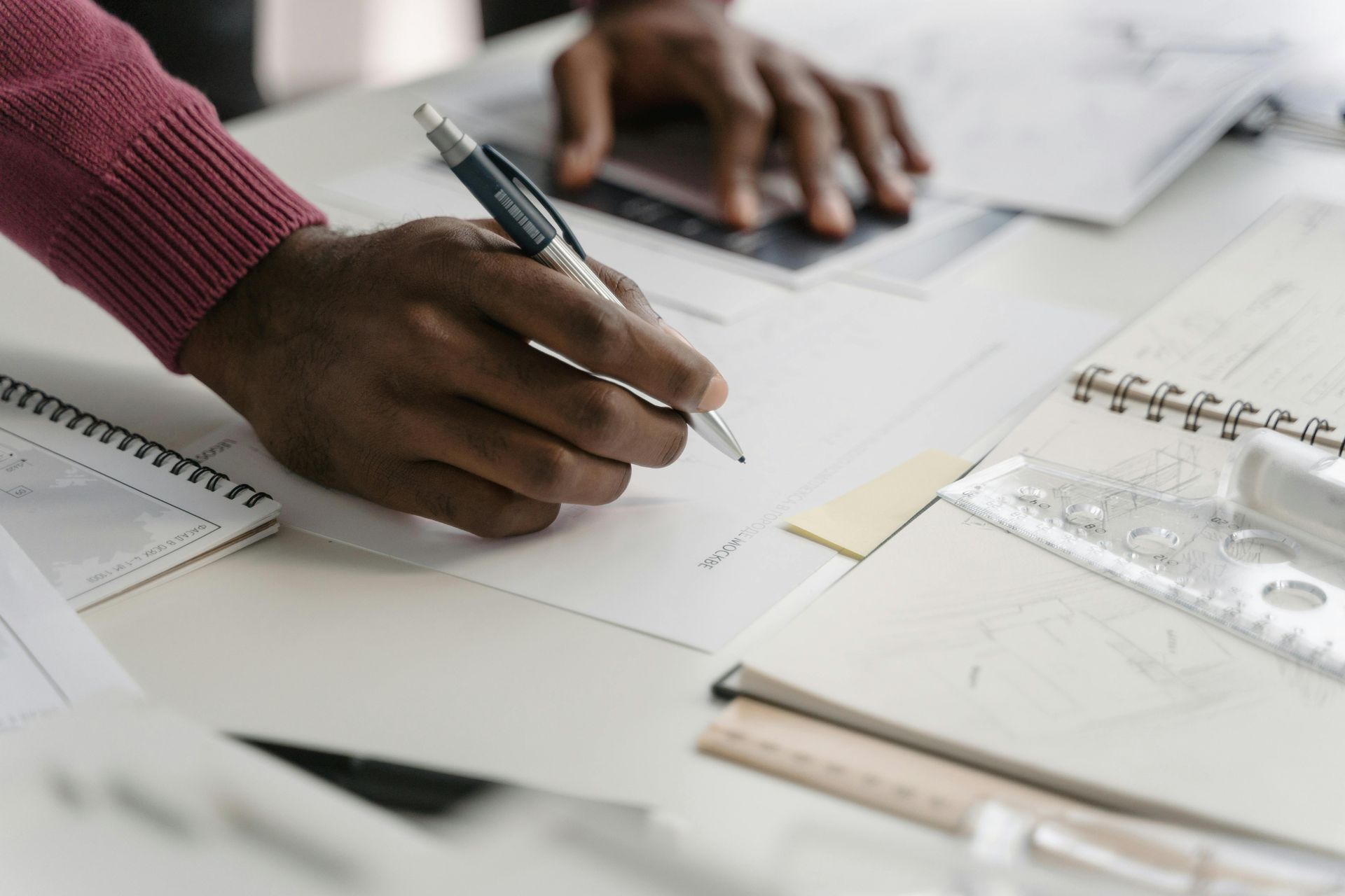 A person is writing on a piece of paper with a pen.