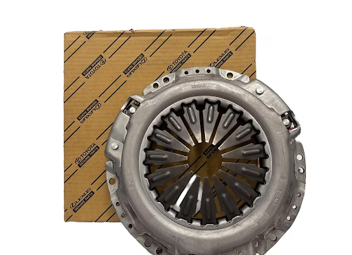 Conjunto de embrague junto a una caja de cartón, posiblemente pieza nueva de coche.