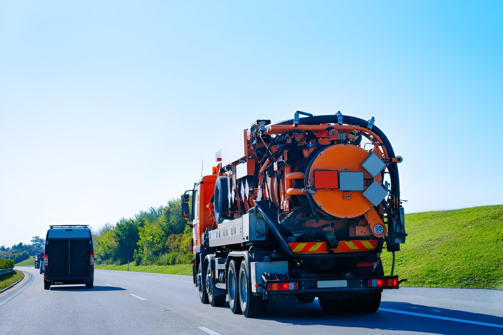 Vacuum Truck is Driving Down a Highway Next to a Van — Precious Drop Water in Murwillumbah, NSW