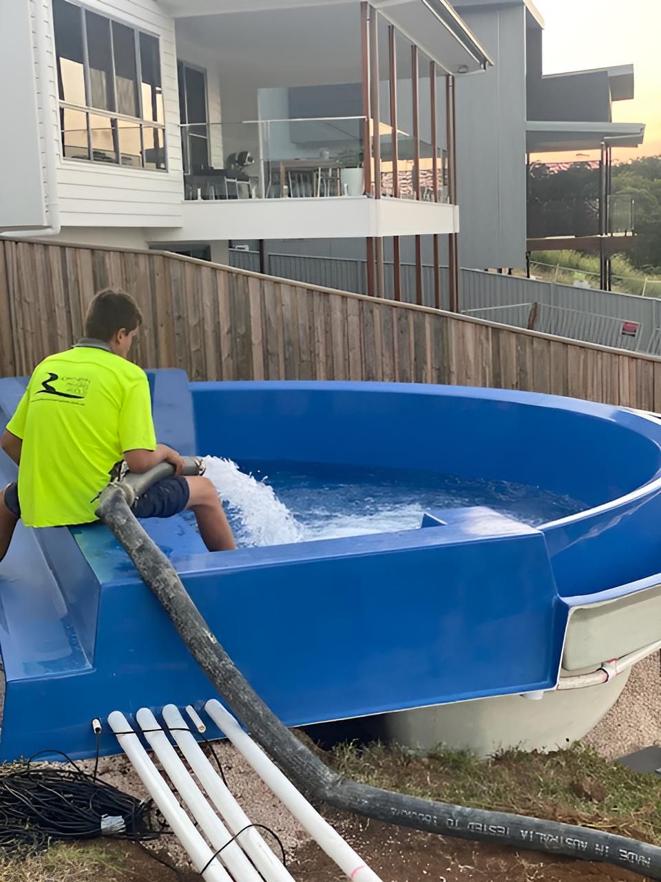 Man in a Yellow Shirt is Pumping Water Into a Pool — Precious Drop Water in Stokers Siding, NSW