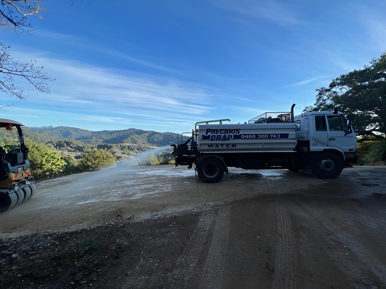 White Truck is Spraying Water on a Dirt Road — Precious Drop Water in Stokers Siding, NSW
