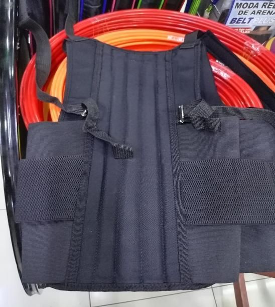 Bolsa multiusos negra con cremalleras y bolsillos de malla para guardar un cable naranja enrollado.