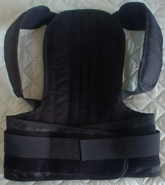 Inserto negro para portabebés con reposacabezas acolchado y soporte lateral sobre una superficie acolchada.