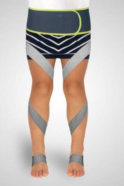 Piernas con mangas de compresión deportivas estampadas y tobilleras sobre un fondo blanco.