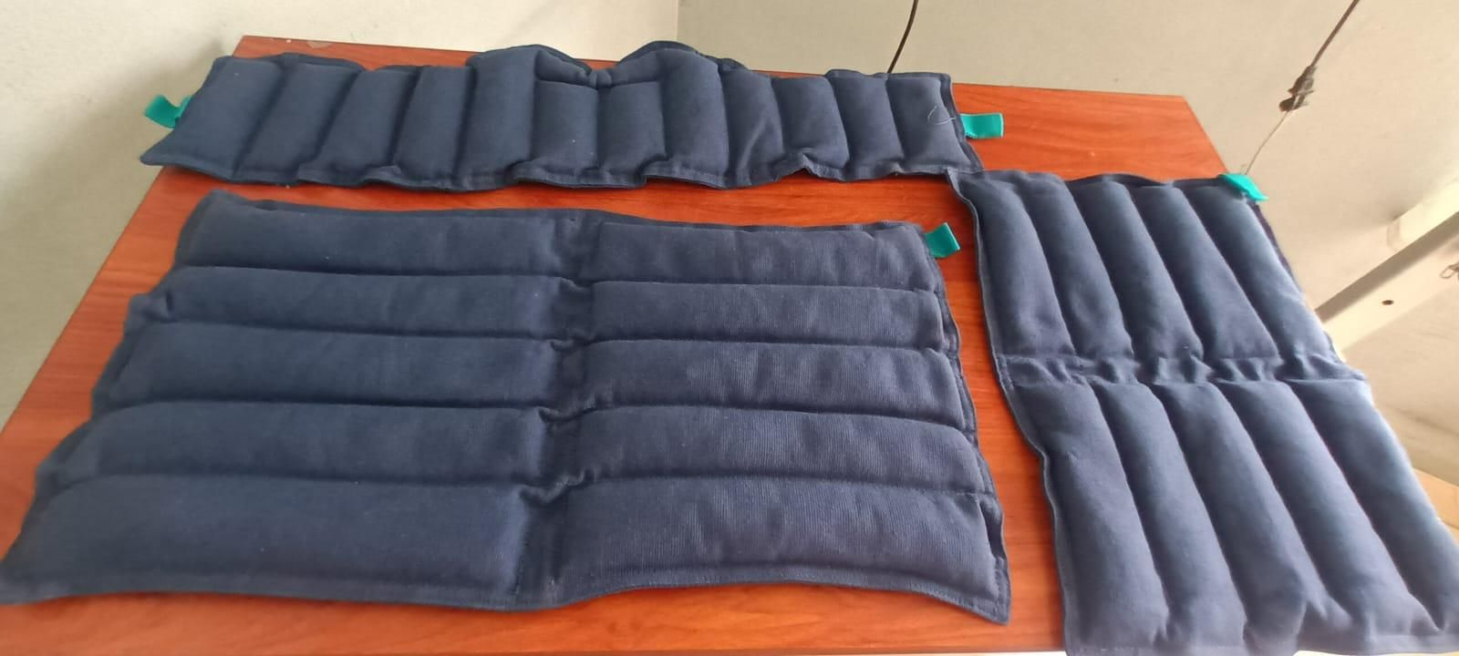 Cojines acolchados azules y naranjas colocados sobre una cama para mayor ventilación o soporte para dormir.