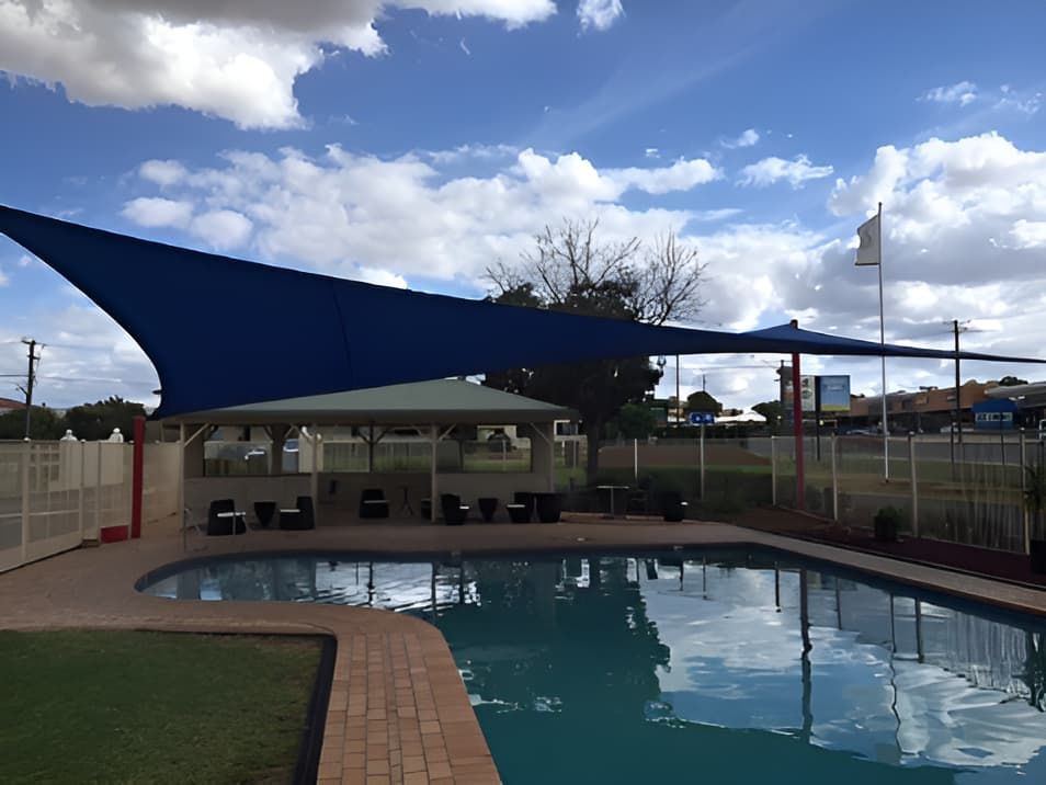A Large Swimming Pool With A Blue Shade Sail Over It — Western Tarps and Motor Trimming In Dubbo, NSW