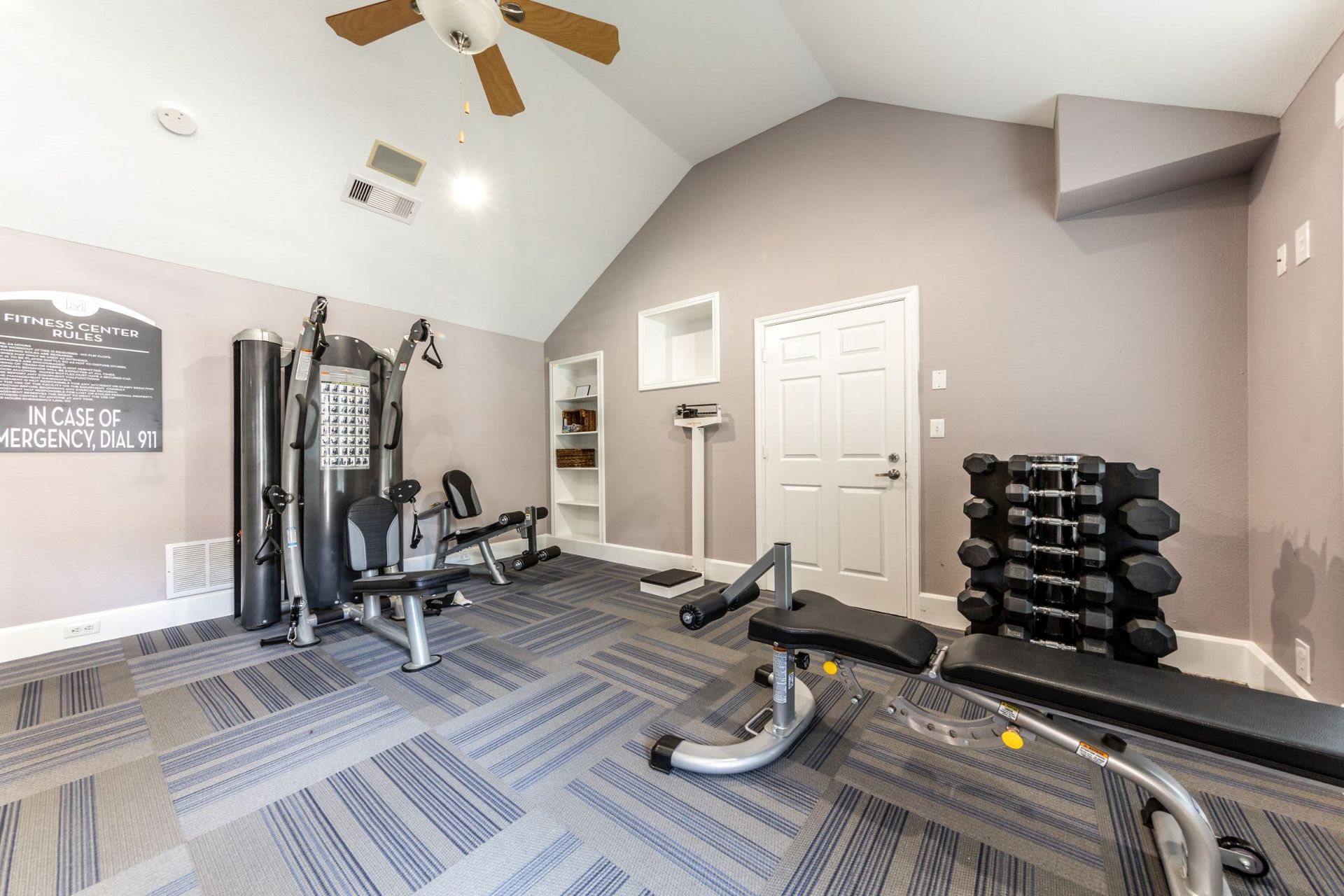 a gym with a lot of equipment and a ceiling fan at Marquis on Memorial in Houston, TX.