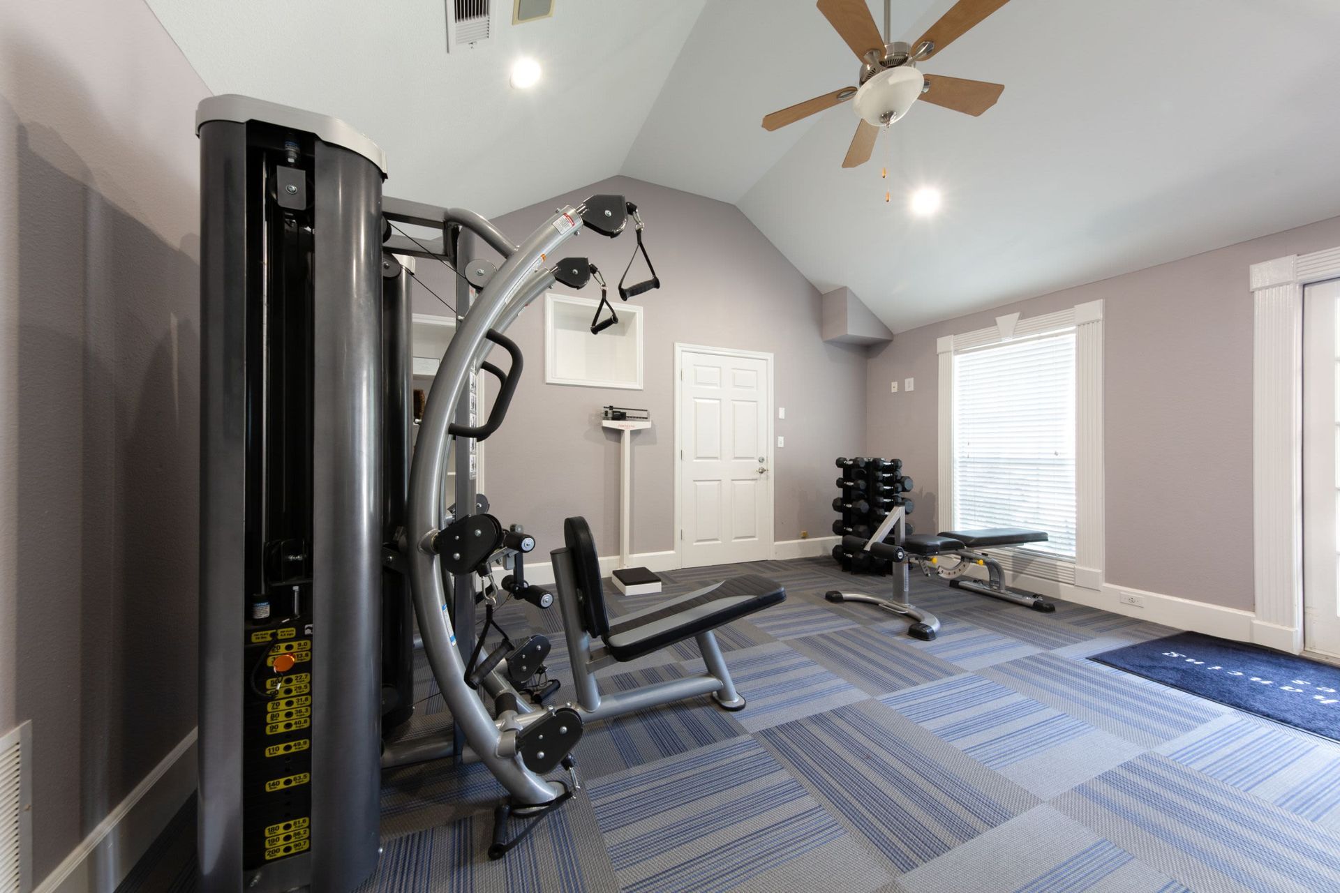 a gym with a ceiling fan and a lot of exercise equipment at Marquis on Memorial in Houston, TX.