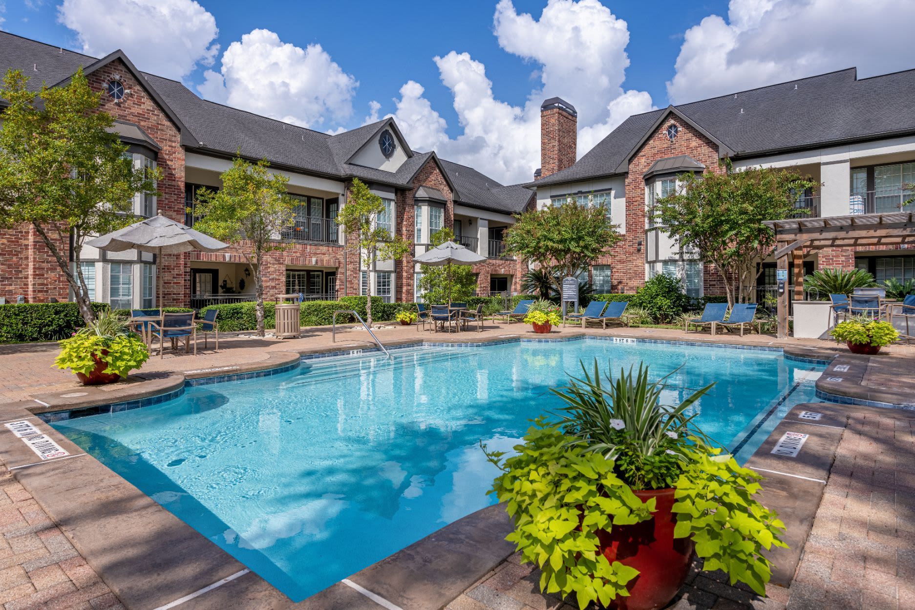 a large swimming pool in front of a large apartment building at Marquis on Memorial in Houston, TX.