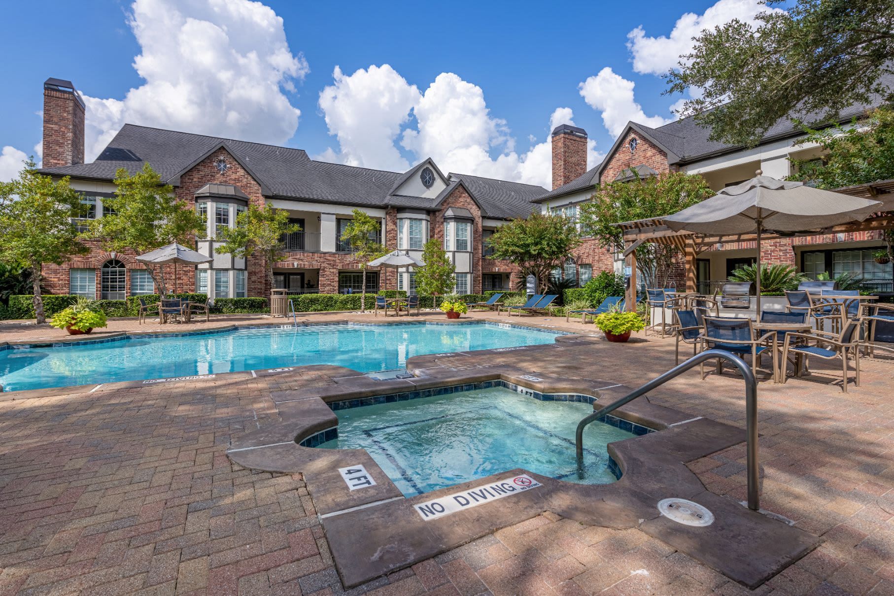 a large swimming pool with a hot tub in front of a building at Marquis on Memorial in Houston, TX.