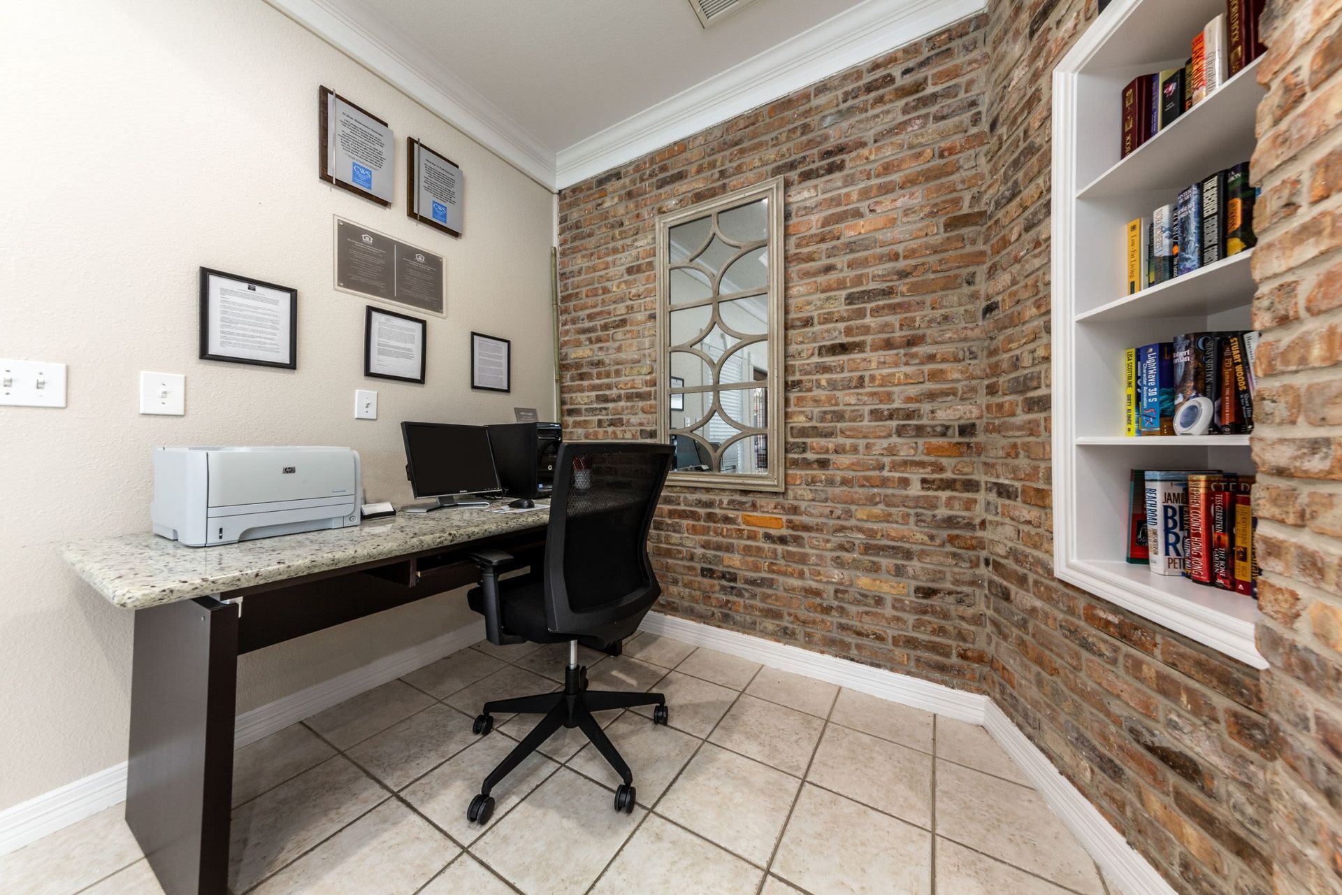 a room with a desk, chair, computer, and printer at Marquis on Memorial in Houston, TX.