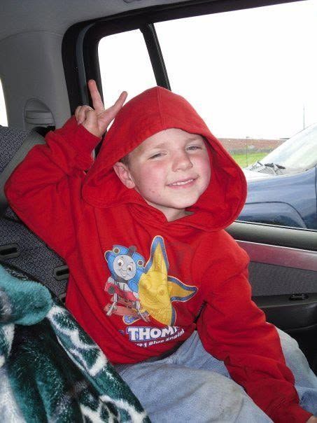 Learn how the Jayden Lamb Memorial Foundation supports families affected by pediatric cancer. Jayden Lamb smiling and making a peace sign while sitting in a vehicle before his pediatric cancer diagnosis.