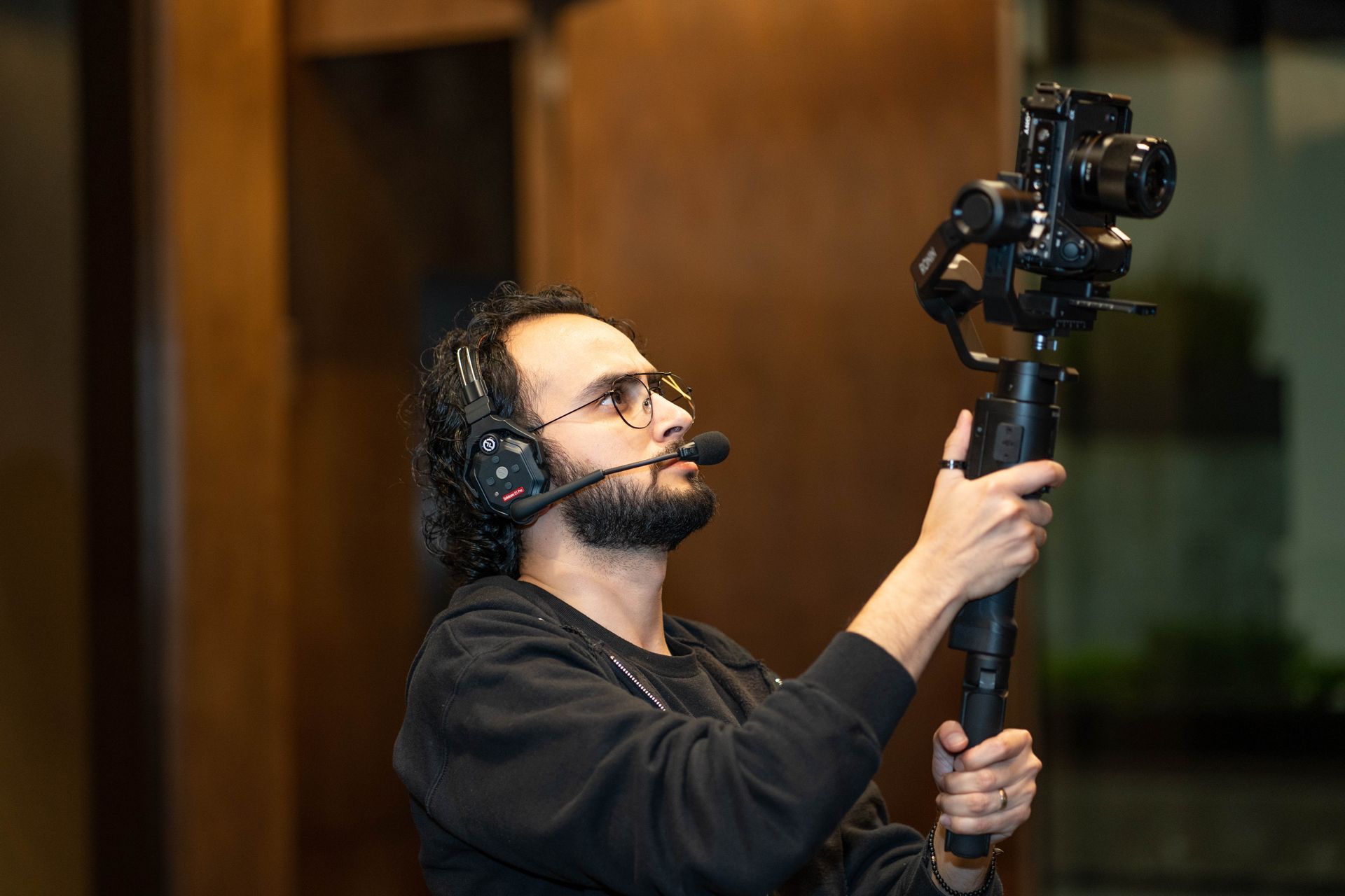 Hombre de equipo de producción audiovisual grabando con una cámara profesional 