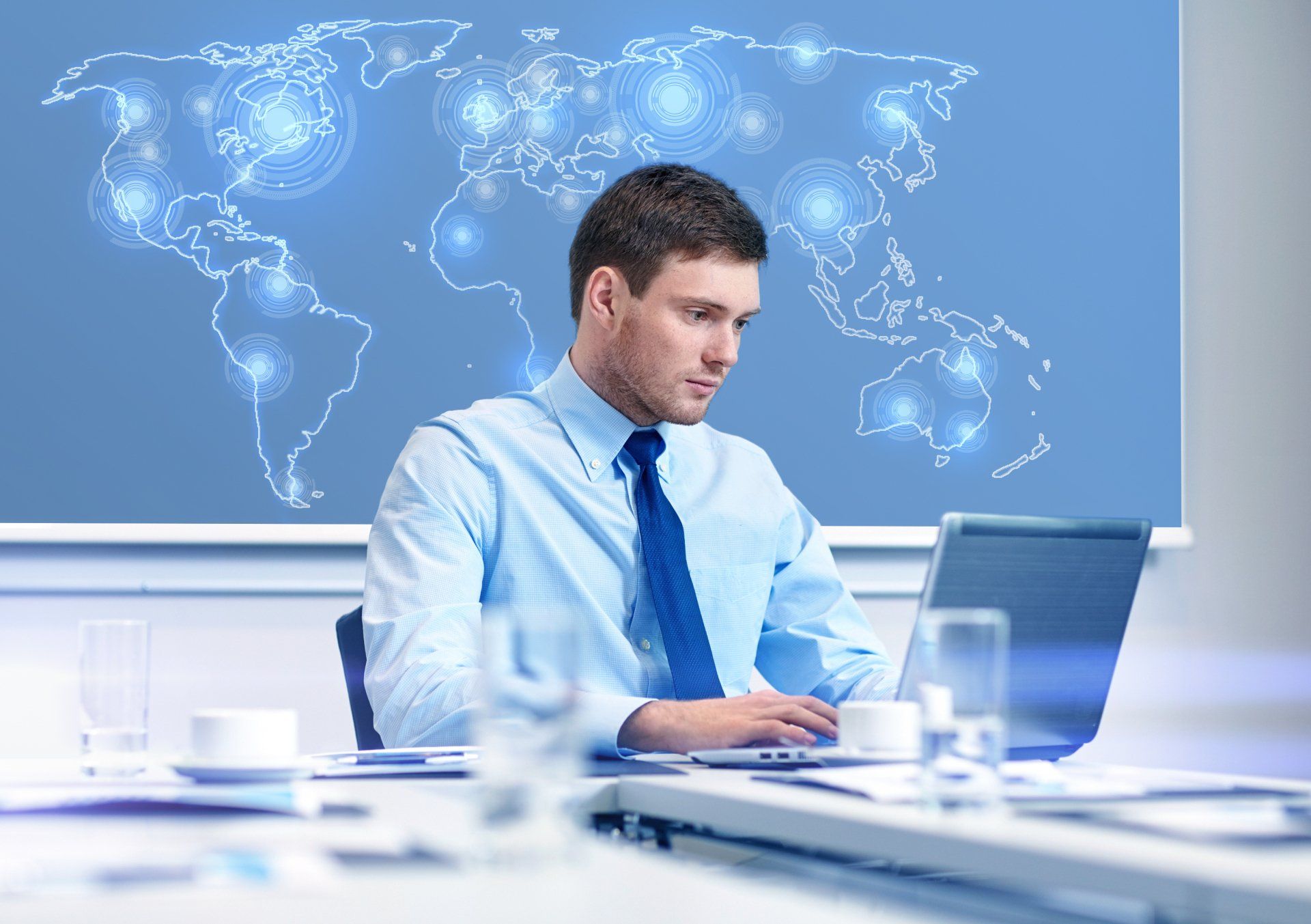Concepto de negocios, personas y trabajo - hombre de negocios con computadora portátil y mapa del mundo virtual sentado en la oficina